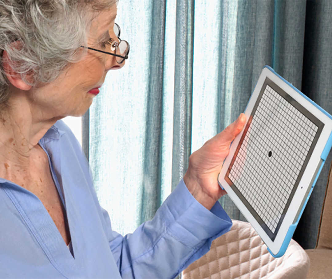 Eine ältere Frau sieht sich das Amsler-Gitter auf dem iPad an.
